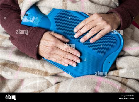 Woman With Period Pains Holding Hot Water Bottle To Abdomem Energy Bills Cold Weather