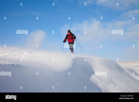 Posed Shot Of A Skier Skiing Through Ground Drifting Snow With Cornice
