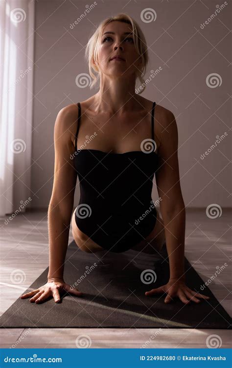 A Beautiful Blonde Girl In A Sports Swimsuit Is Engaged In Yoga Practicing Different Asanas