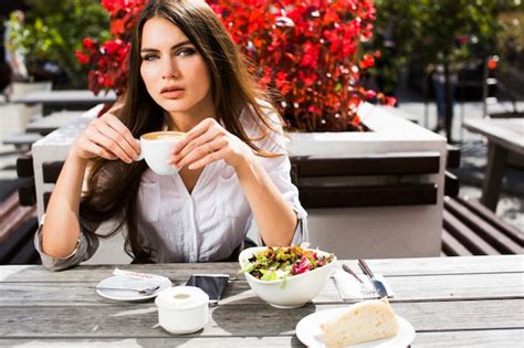 Brunette Frau Sitzt Am Tisch Mit Kaffee Kostenlose Foto