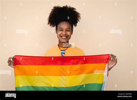 Happy African Gay Woman Celebrating Pride Holding Rainbow Flag Outdoor LGBT Concept Stock