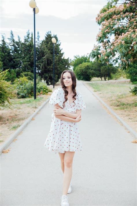 Brunette Woman In White Polka Dot Summer Dress Walking Down The Road Stock Photo Image Of