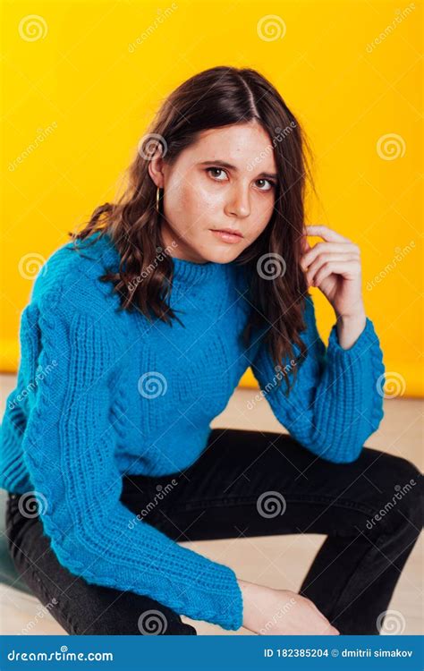 Portrait Of A Skinny Fashionable Brunette Woman In Jeans And A Blue Sweater Stock Photo Image