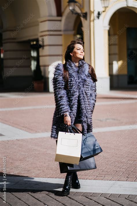 Gorgeus Smiling Brunette With The Long Straight Hair Wearing In A Fur Coat And The White Skirt
