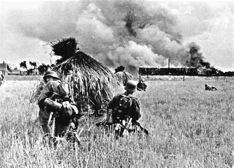 Немецкие солдаты в поле на окраине горящей советской деревни — военное фото