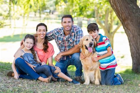 Família feliz seu cachorro no parque Foto Premium