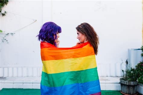 Premium Photo Side View Of Lesbian Couple Wearing Rainbow Flag Outdoors