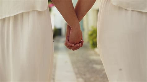 Free Stock Video Close Up Of An Unrecognizable Lesbian Brides In White Dresses Holding Hands