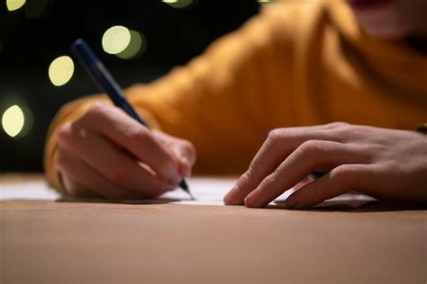 A person writing on a piece of paper with a pen photo – Free Human ...