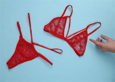 Conjunto de lingerie sexy vermelha e mão sobre fundo azul Foto Premium