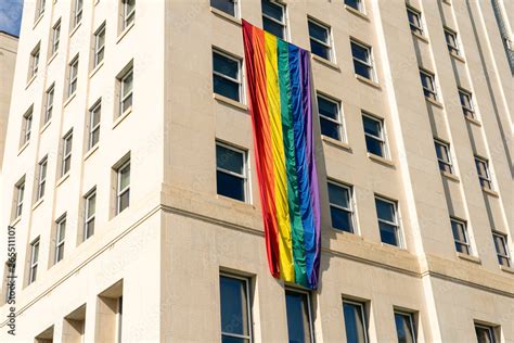 A Big Gay Pride Rainbow Striped Flag Is Waving On A House Huge Rainbow Flag Is Hanging On The