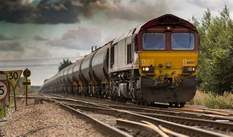 A Moving Freight Train On Railroad Tracks On A Cloudy Day Freight
