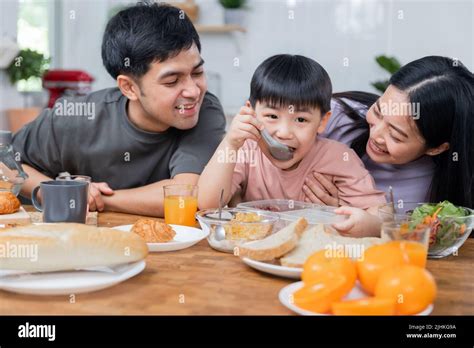 Happy Asian family, young boy eating healthy food together Stock Photo ...