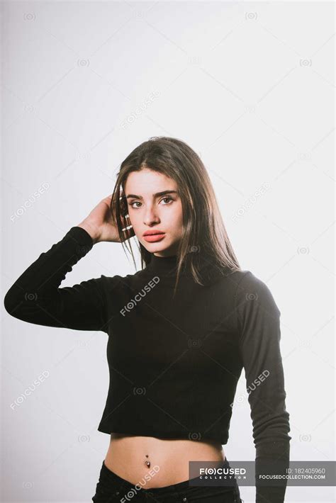 Brunette Girl Touching Hair And Looking At Camera Vertical Stylish
