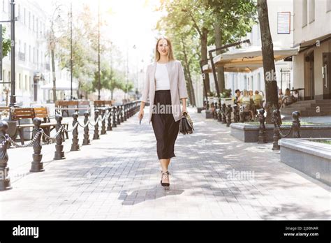 Casual Young Woman Walking Along A City Street Stock Photo Alamy