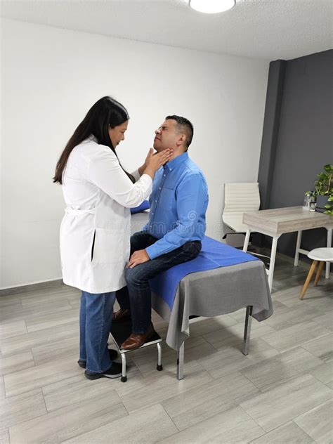 Latina Female Doctor Checks Dark Skinned Male Patient In Office For Sore Throat Due To Viruses