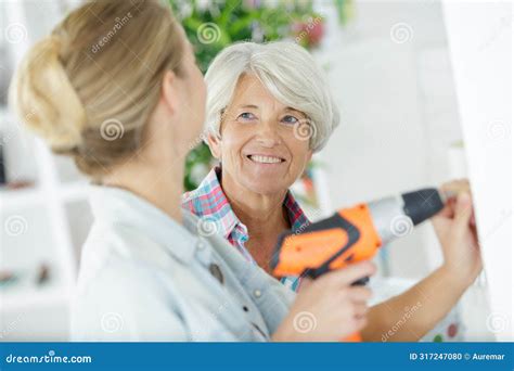 Smiling Blonde Granddaughter With Grandmother Reconstructing Home Interior Stock Photo Image