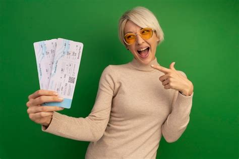 Jeune Fille Blonde Impressionn E Tenant Et Pointant Les Billets D Avion En Les Regardant Isol S