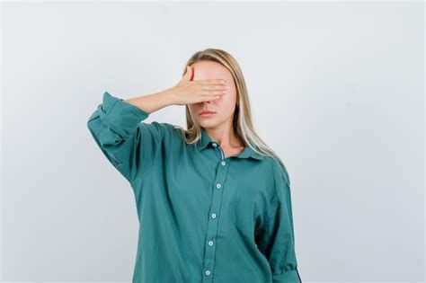 Fille Blonde Couvrant Les Yeux Avec La Main En Blouse Verte Et à La Grave Photo Gratuite
