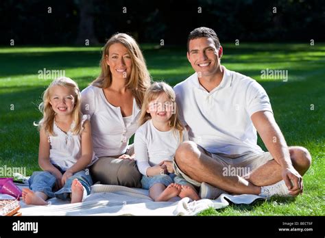 Eine junge Familie mit Mutter Vater und zwei blonde Töchter mit einem Picknick in einem Sonne