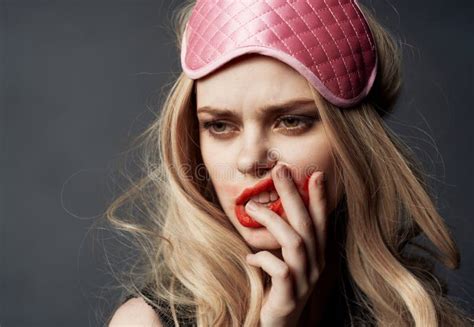Blonde Woman Smeared Makeup On Her Face On A Gray Background And A Pink Sleep Mask On Her Head
