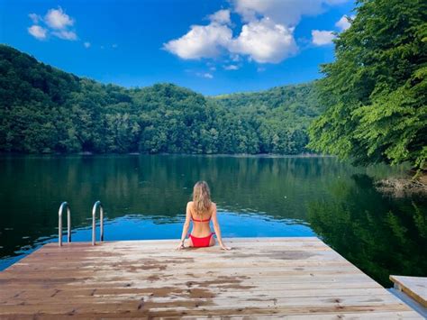 Premium Photo Woman In Red Bikini Sitting Down On A Wooden Pontoon Looking At The Lake