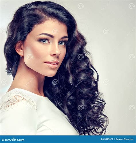 Brunette με τη μακριά πυκνή σγουρή τρίχα Στοκ Εικόνες εικόνα από