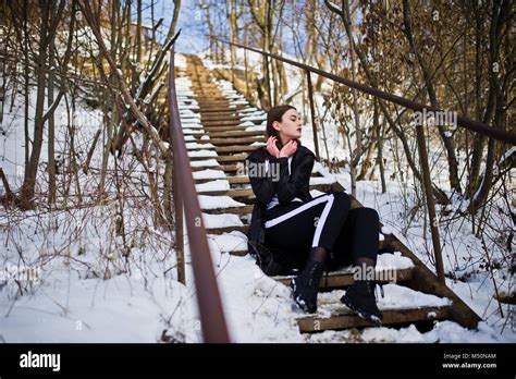 Fashionable Long Legs Brunette Model In Long Black Cloak Posed Outdoor At Winter Day Stock Photo