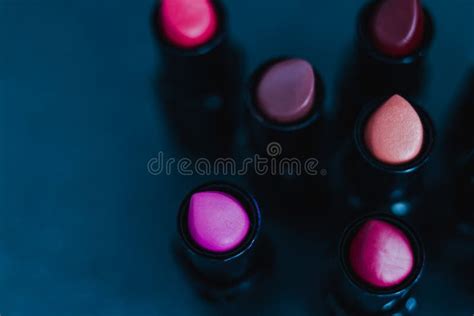 Group Of Red Pink And Nude Lipsticks With Different Colors And Textures On Dark Table Stock