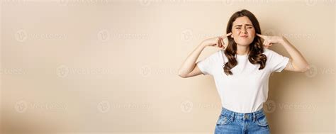 Annoyed young woman shut ears from loud noise, feeling discomfort and