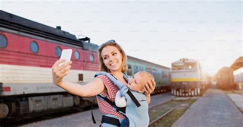 Madre Joven Que Viaja Con Un Bebé En Tren Una Mujer Con Un Smartphone Y Su Hijo En La Estación