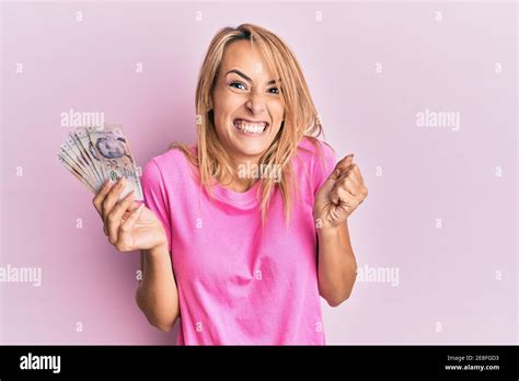 Beautiful Blonde Woman Holding 2 Singapore Dollars Banknotes Screaming
