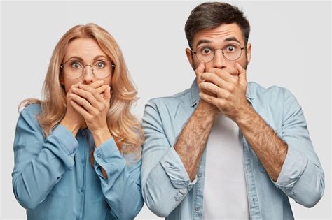 Belle Femme Blonde Sans Voix Et Bel Homme Se Couvrent La Bouche Ayant Peur De Voir Quelque