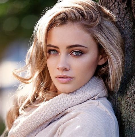 A Beautiful Blonde Woman Leaning Against A Tree