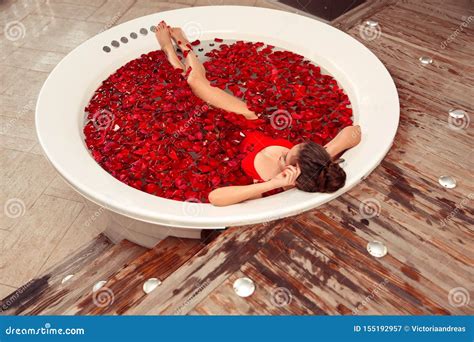 Spa Relax Beautiful Girl In Jacuzzi Bikini Woman Lying In Round Bath With Red Rose Petals