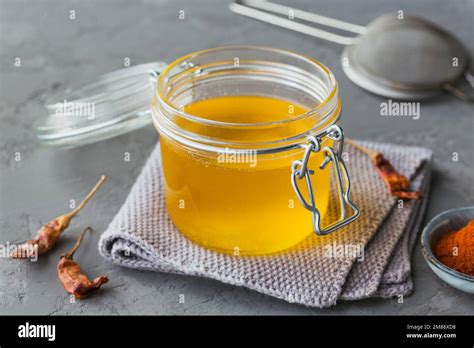 Healthy Homemade Ghee Or Clarified Butter In A Jar Chili And Paprika Powder On Grey Concrete