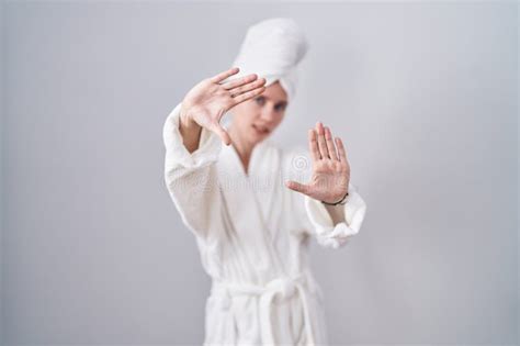 Blonde Caucasian Woman Wearing Bathrobe Doing Frame Using Hands Palms And Fingers Camera