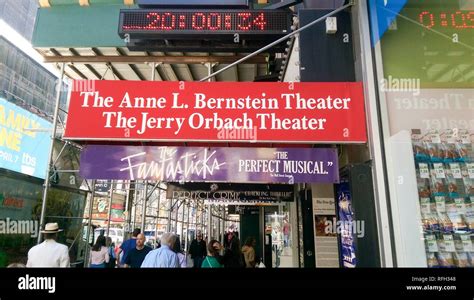 Crowds walk under scaffolding past the Anne L Bernstein Theater and ...