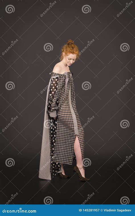 Ragazza Dai Capelli Rossi In Un Vestito Lungo Con Le Spalle Nude Su Un Fondo Scuro Immagine