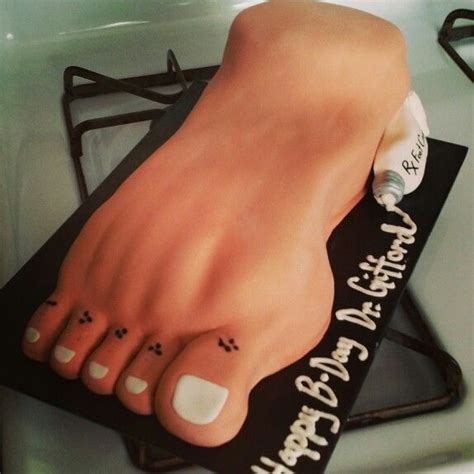 There Is A Cake Shaped Like A Foot On Top Of A Table With Writing On It