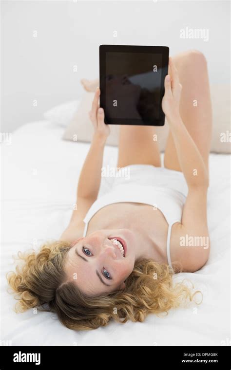 Pretty Happy Blonde Lying On Bed Holding Tablet Stock Photo Alamy