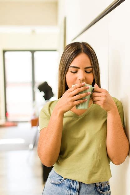 Bonita mujer latina tomando una taza de café en casa Foto Premium