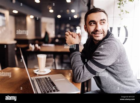 Handsome Man Drinking Coffee While Working In A Cafe Stock Photo Alamy