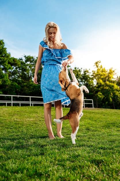 Belle Jeune Fille Blonde Marchant Jouant Avec Un Chien Beagle Dans Le Parc Photo Gratuite