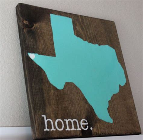 A Wooden Sign That Says Home With The State Of Texas Painted On Its Side