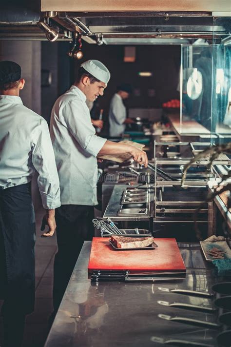 Two Handsome Chefs With Apron On Naked Muscular Body With Kitchen Utensils On Blue Background