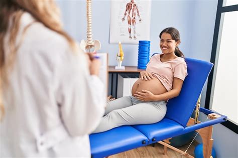 Paciente grávida jovem latina tendo sessão de fisioterapia na clínica