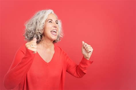 Premium Photo Excited Mature Woman Celebrating While Raising The Fists