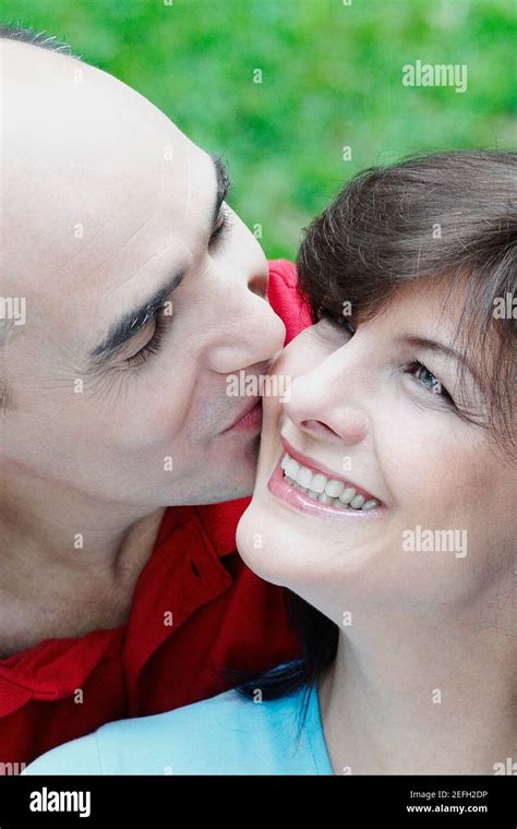 Close Up Of A Mature Man Kissing A Mature Woman Smiling Stock Photo Alamy