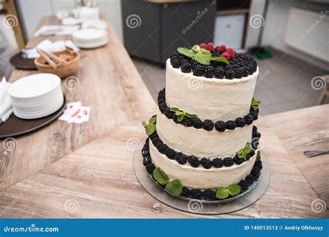 Naked Wedding Cake Decorated With Red Berries And A Dusting Of Icing Sugar Stock Image Image